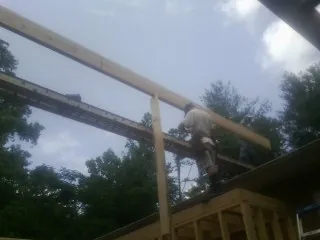 Carpenter setting a ridge beam over a new addition frame — Ice Dam Removal by Roofing Brothers in Summitville