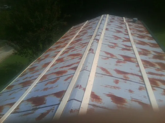 Rusted metal roof panels with new wood purlins before replacement — Storm Damage Roof Repair in Summitville by Roofing Brothers