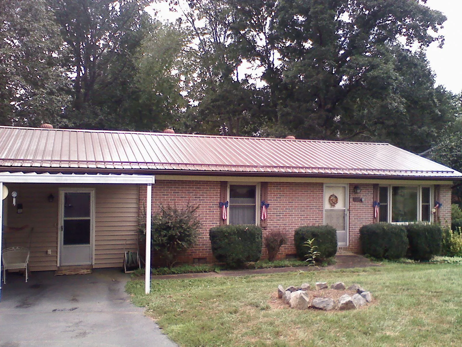 Bronze metal roof and carport on a brick ranch home — Roof Repair work by our crew in Summitville